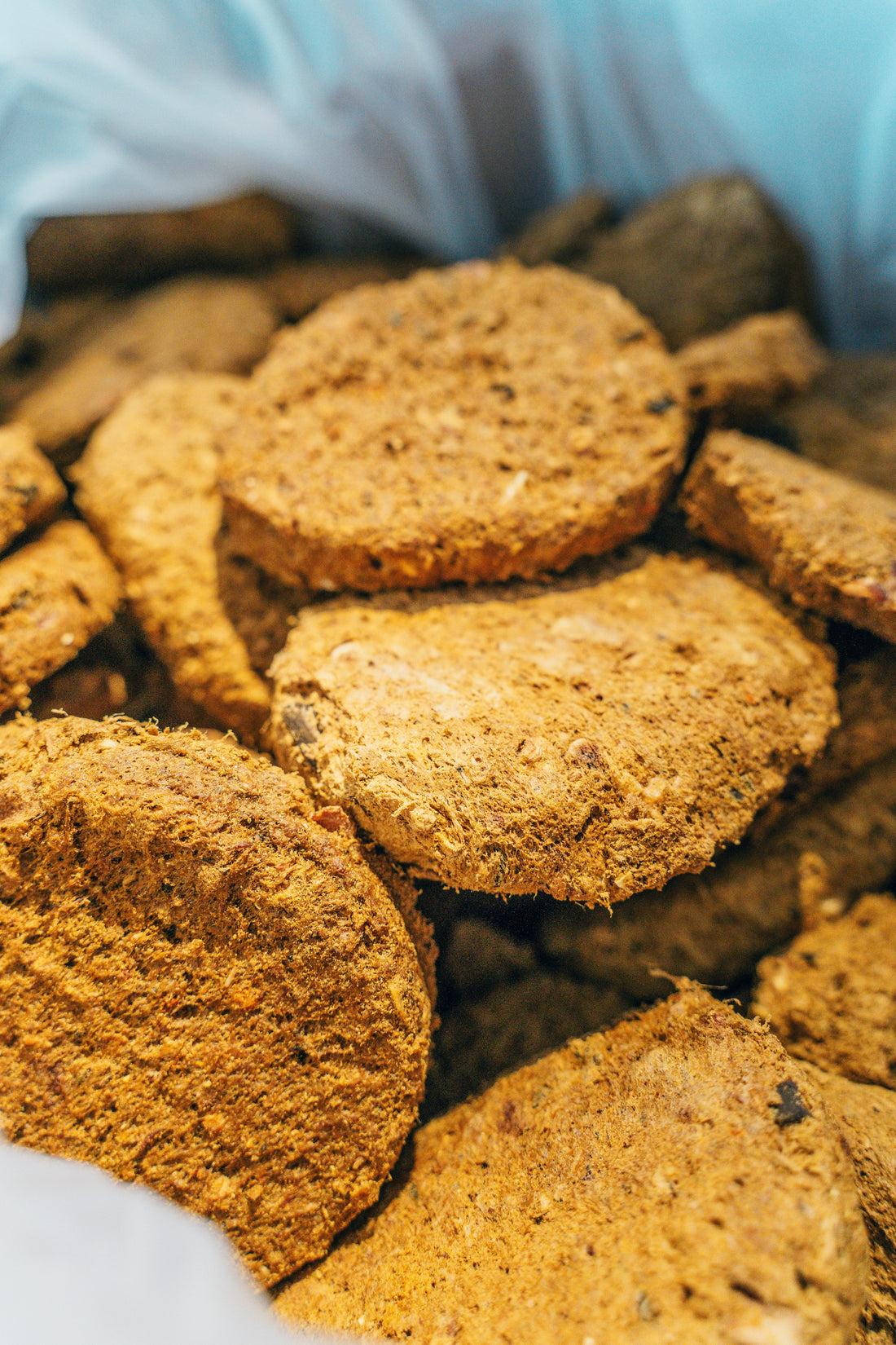 Hypoallergenic freeze-dried meal in round, brown patties stacked together.