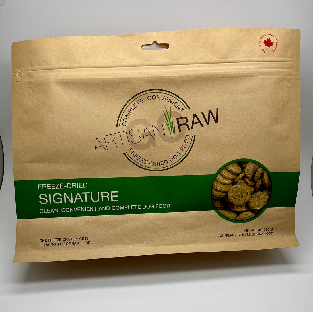 Artisan Raw Signature freeze-dried dog food bag, 770 g size, kraft packaging with a green label, showing round freeze-dried pucks visible through a circular window.