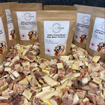 Several Artisan Raw Bison Tendons treat bags arranged upright on a bed of dried bison tendon pieces.